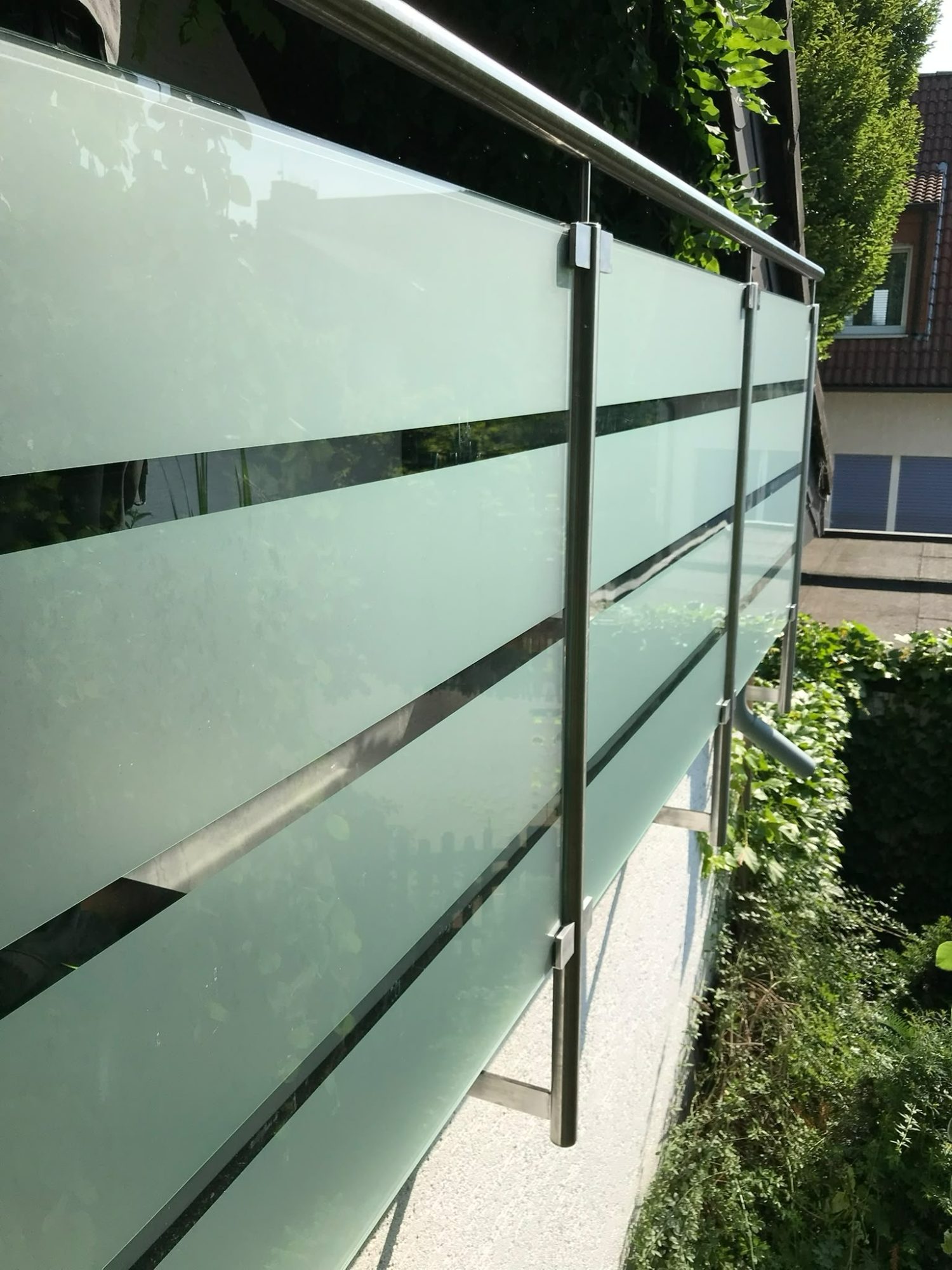 Edelstahlgeländer am Balkon mit sandgestrahltem Glas, seitliche Befestigung